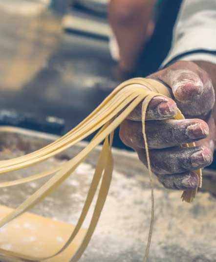 Man holding homemade pasta in his hand
