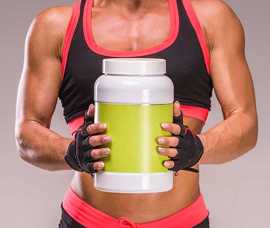 fit woman holding a bottle of protein powder