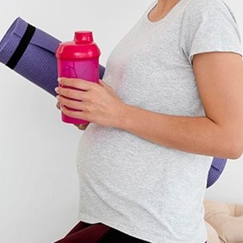 Woman holding protein shake while preparing to work out