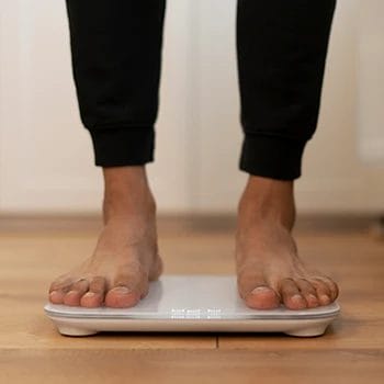 A close up shot of a person checking weight on a scale
