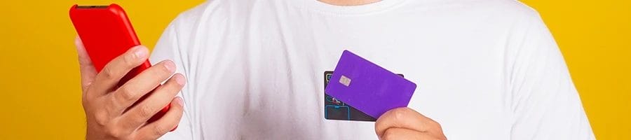 A man holding his smartphone and credit cards to buy the best fish oil for body building