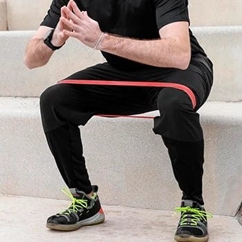 A man using resistance bands for squats