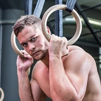 A strong man using gymnastic rings