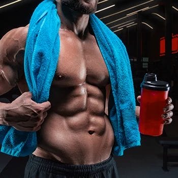 A body builder holding a drink with vegan testosterone booster with the right dosage