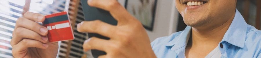 A person online shopping with his phone and credit card
