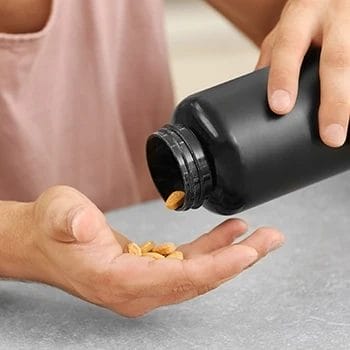 A man pouring CoQ10 supplement on his palm