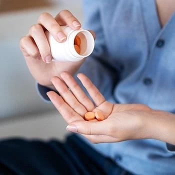 Woman getting the right dosage amount of prebiotic supplement on her palm