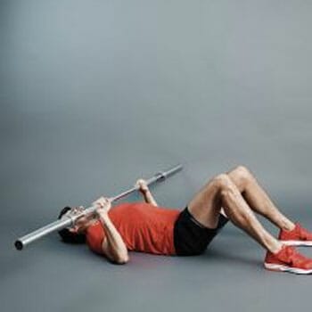 man doing chest press with a body bar