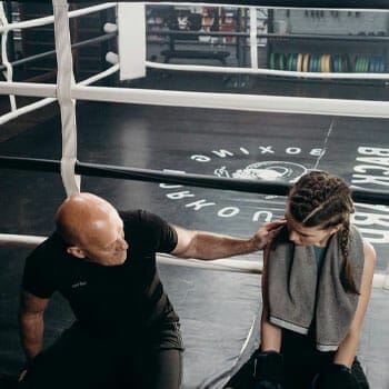 woman with her coach in a boxing ring
