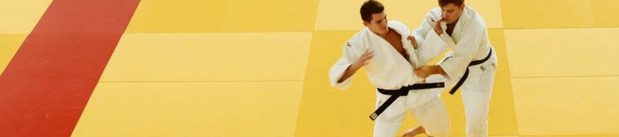 Two athletes performing judo in an open space