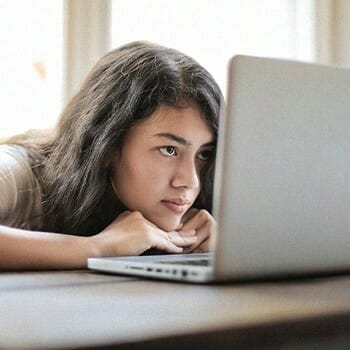 A girl searching and looking on a laptop