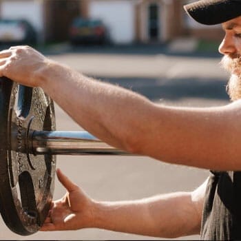 man fixing a barbell plate