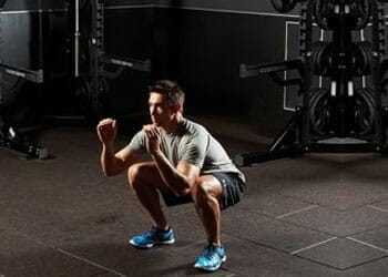 man in a gym about to do a squat jump