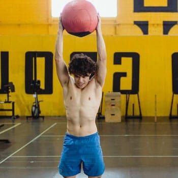shirtless man slamming a medicine ball