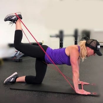 woman in a resistance band position in a gym