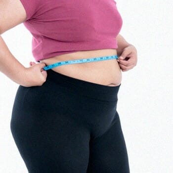 woman measuring her stomach with a measuring tape