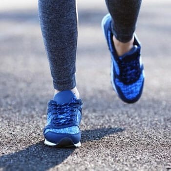 close up image of a person's blue rubber shoes while walking