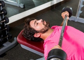 man working out with a barbell in a bench
