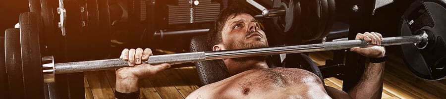 man lifting a barbell while laying down