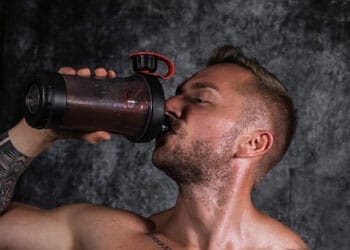 man chugging a jug of supplement drink