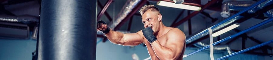 shirtless white man using a punching bag