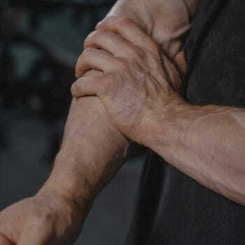 man holding his painful forearm