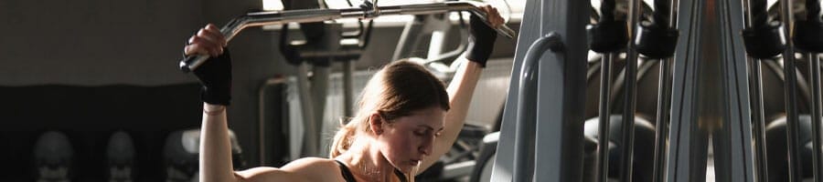woman frustrated using a lat machine