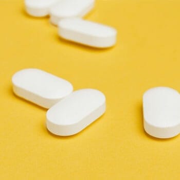 yellow background with white pills on it