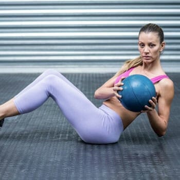 woman in gym clothes in a russian twist position