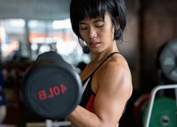 asian woman lifting dumbbells