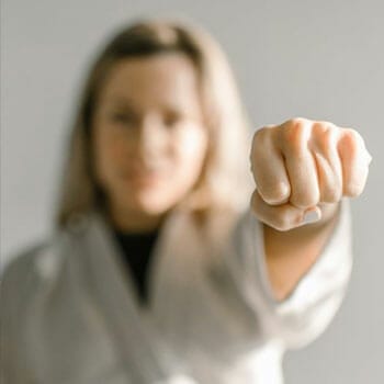 blonde female in a judo uniform showing her fist