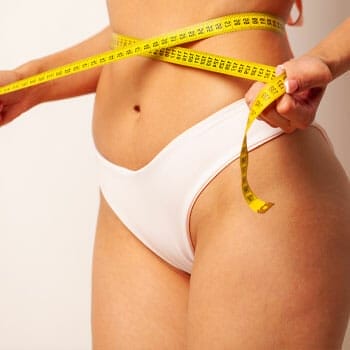 woman wearing undies with a measuring tape around her waist