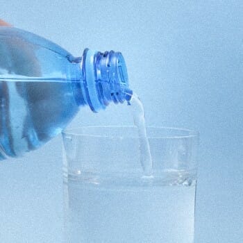 a bottle of water being poured in a glass