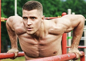 A guy doing a chest dips workout outdoor