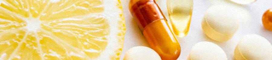 Close up image of an orange slice and different pills