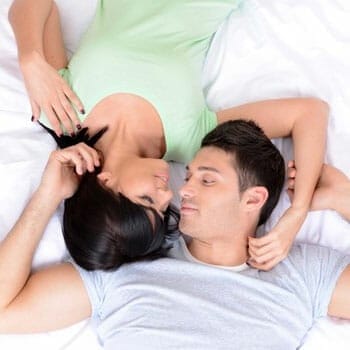 couple in bed staring at each other