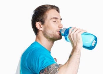 white man chugging water from a blue jug