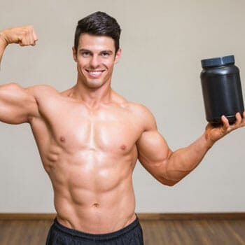 shirtless man raising up a supplement container and flexing his biceps
