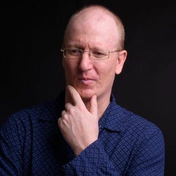 bald man resting his hand on his chin thinking