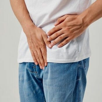 man covering his crouch in pain