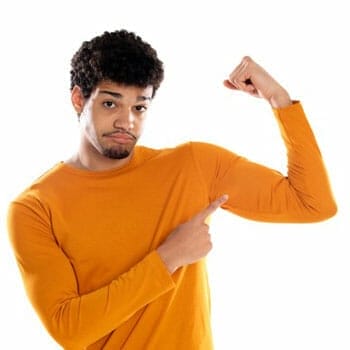 black man in a sweatshirt flexing and pointing at his biceps