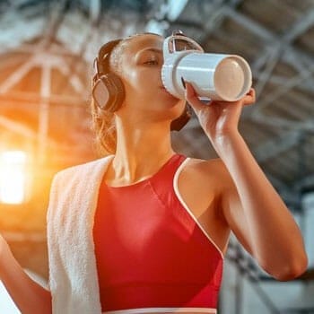 woman chugging a jug after workout