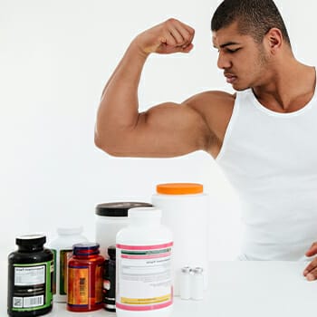 Different multivitamins and an athlete flexing his mucles