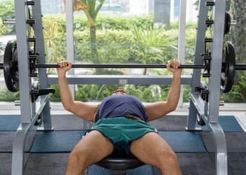man laying down on a bench press
