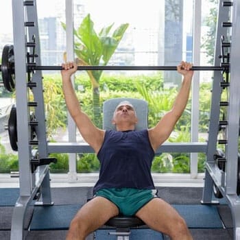 man working out on a bench in a gym