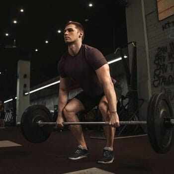 man doing deadlifts in a gym