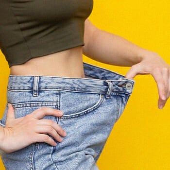 A woman holding a loose jeans