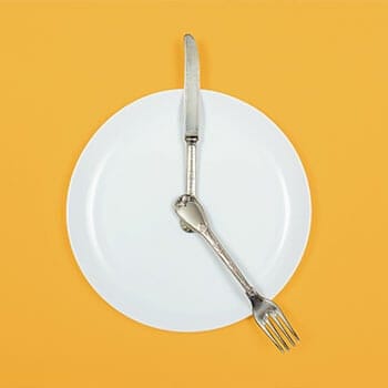 empty plate with utensils on it with yellow background