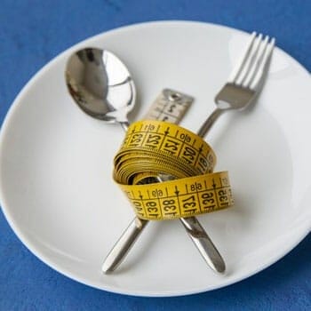 fork and spoon tied in a measuring tape on an empty plate