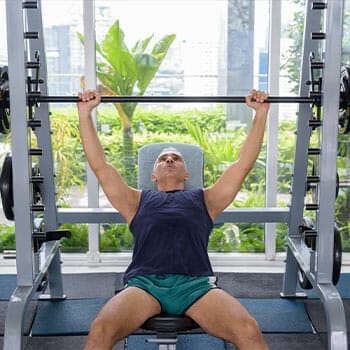 man in a gym doing bench presses